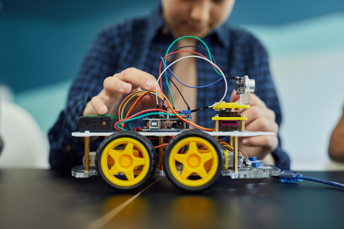 boy adjusting wires on a half-built toy truck