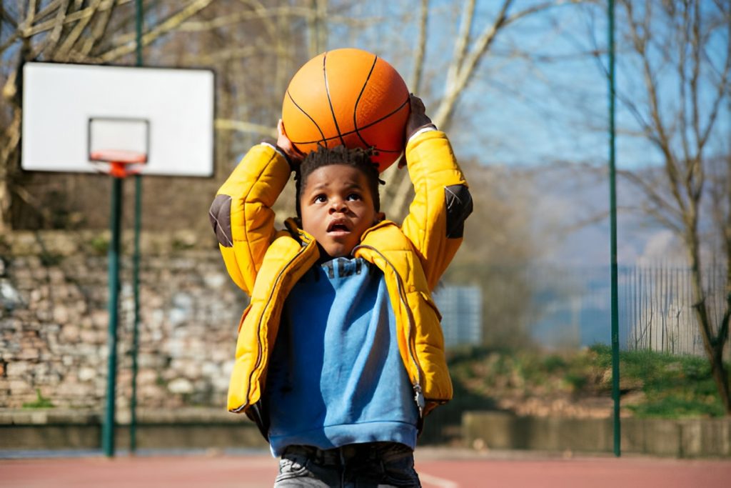 boy trying to shoot a ball into a hoop