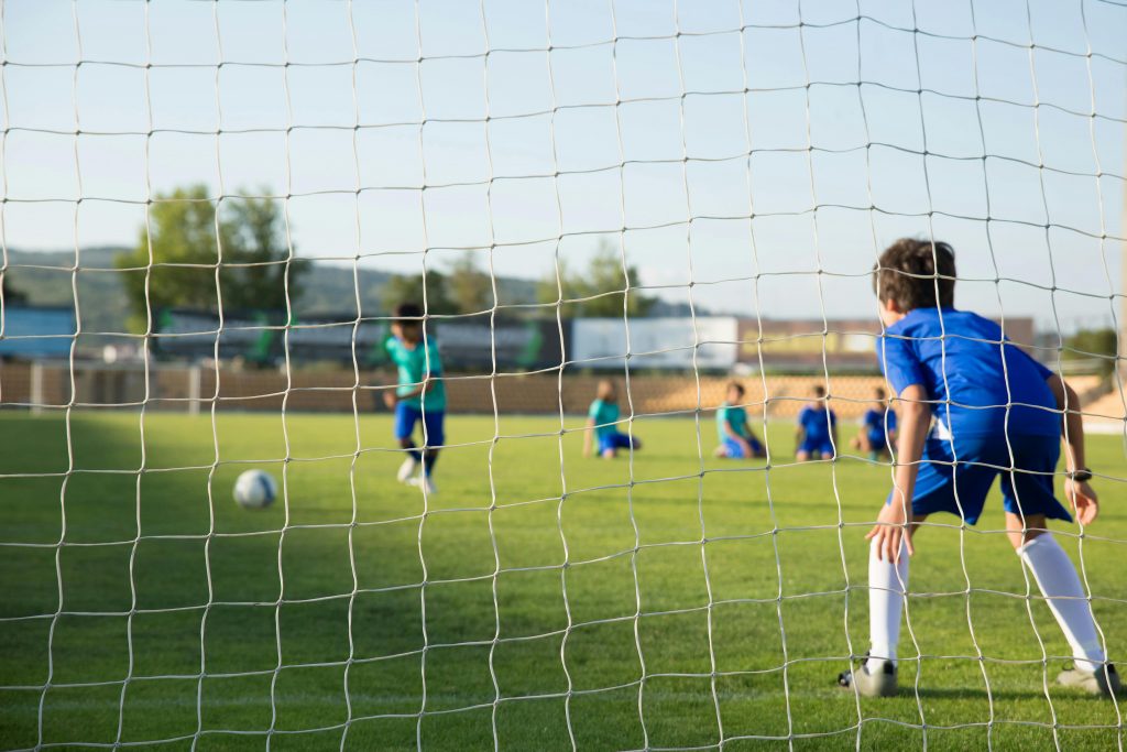 boys playing soccer in a school field
